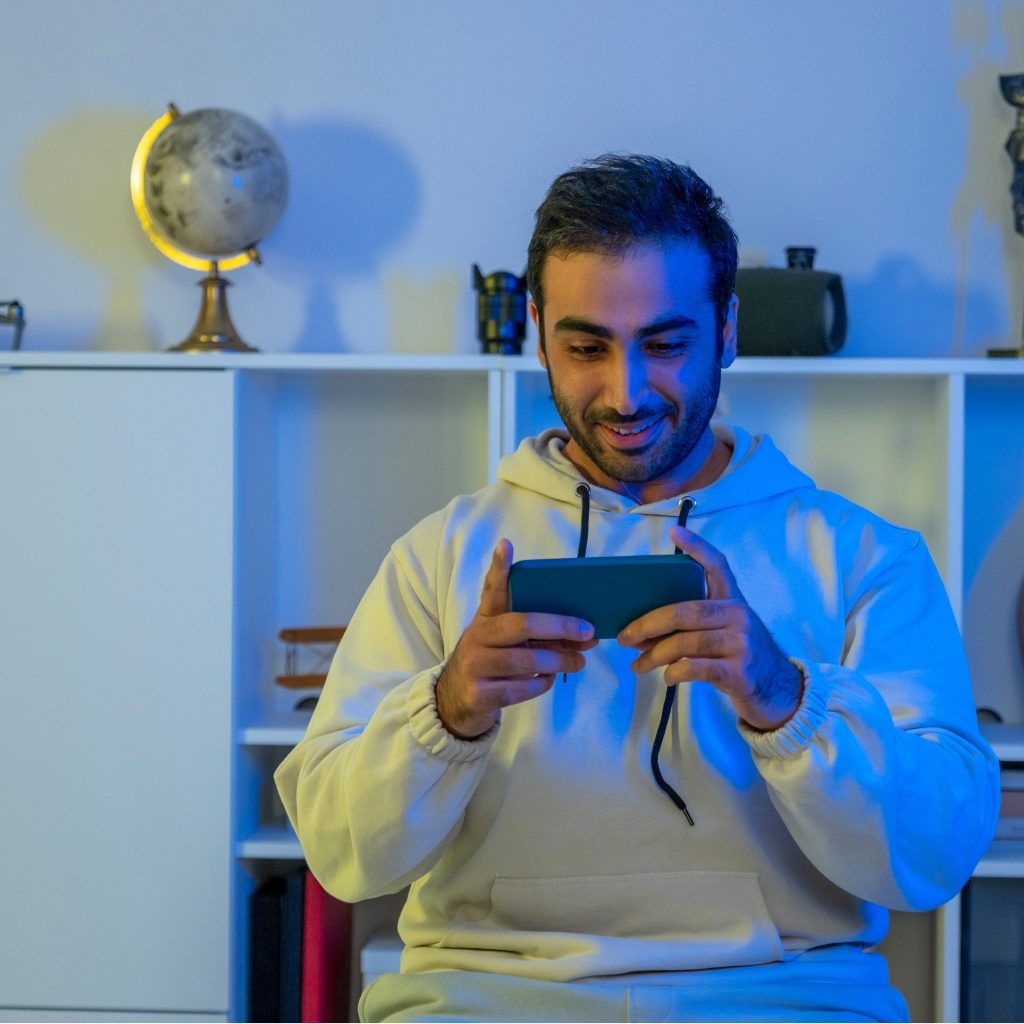 Young gamer man playing mobile game