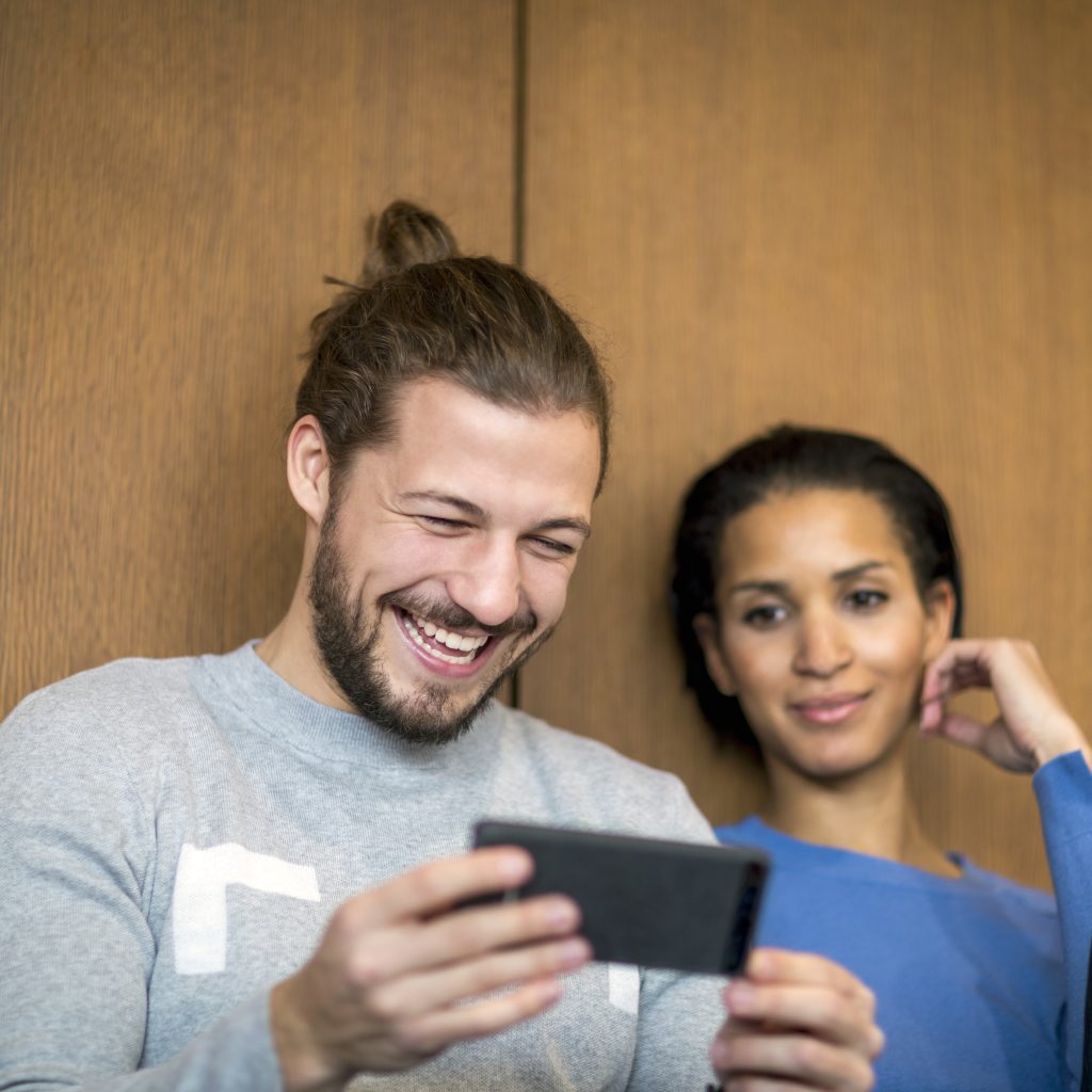 Portrait of laughing man looking at cell phone